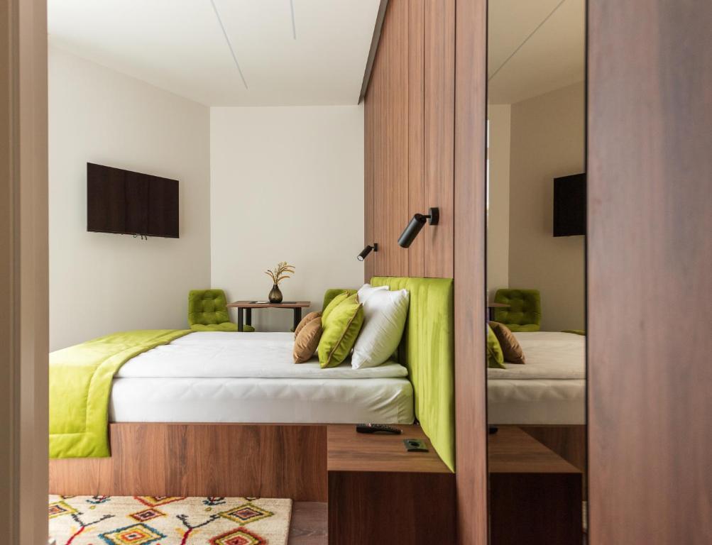 萨拉热窝Apartments EMERALD Free Garage Parking的一间卧室配有两张床和镜子