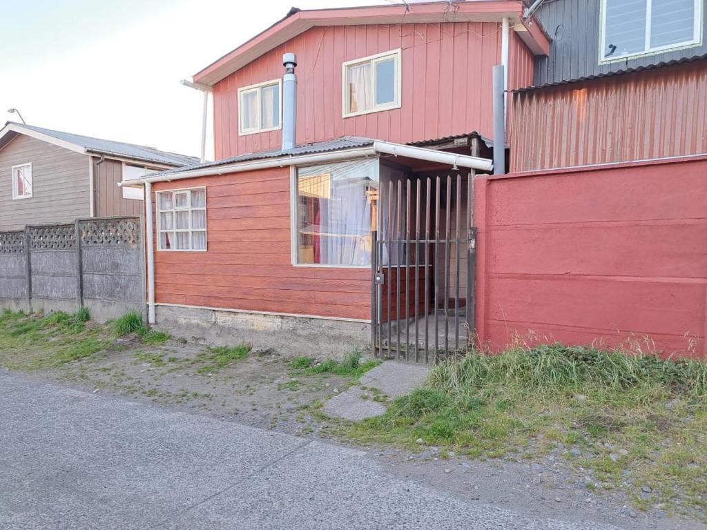 蒙特港Cabaña Alba的前面有栅栏的红色房子