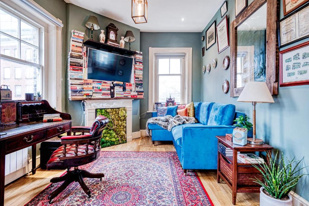 伦敦Sunny Corner Apartment in Center of London的客厅配有蓝色的沙发和钢琴