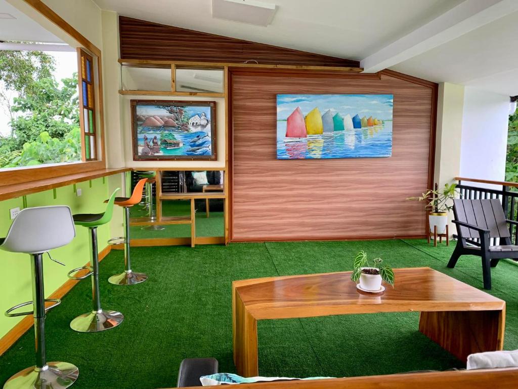 邦劳SUNSHINE STAY PANGLAO的客厅配有桌子和绿色地毯