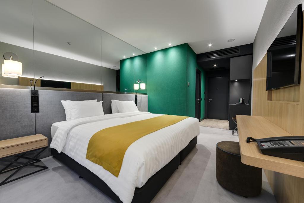 第比利斯Glarros OldTown的一间卧室设有一张大床和绿色的墙壁