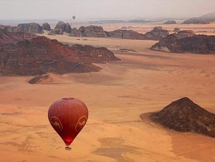 瓦迪拉姆Flower Life Camp的热气球在沙漠上空飞行