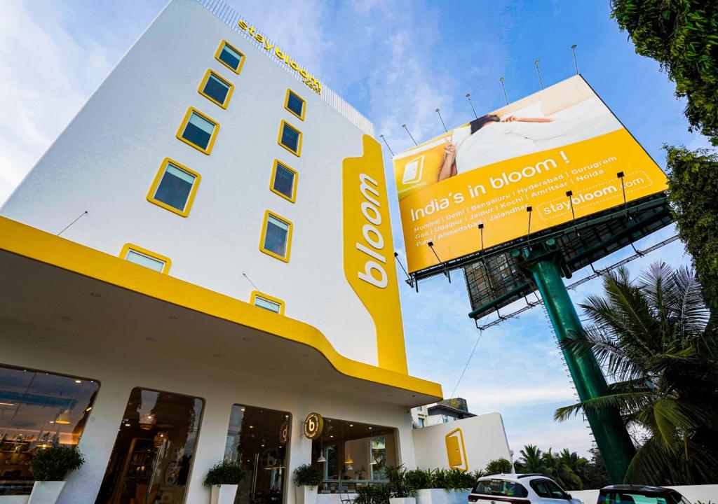 德瓦纳哈利-班加罗尔Bloom Hotel - Bengaluru Airport的黄色和白色的建筑,上面有标志