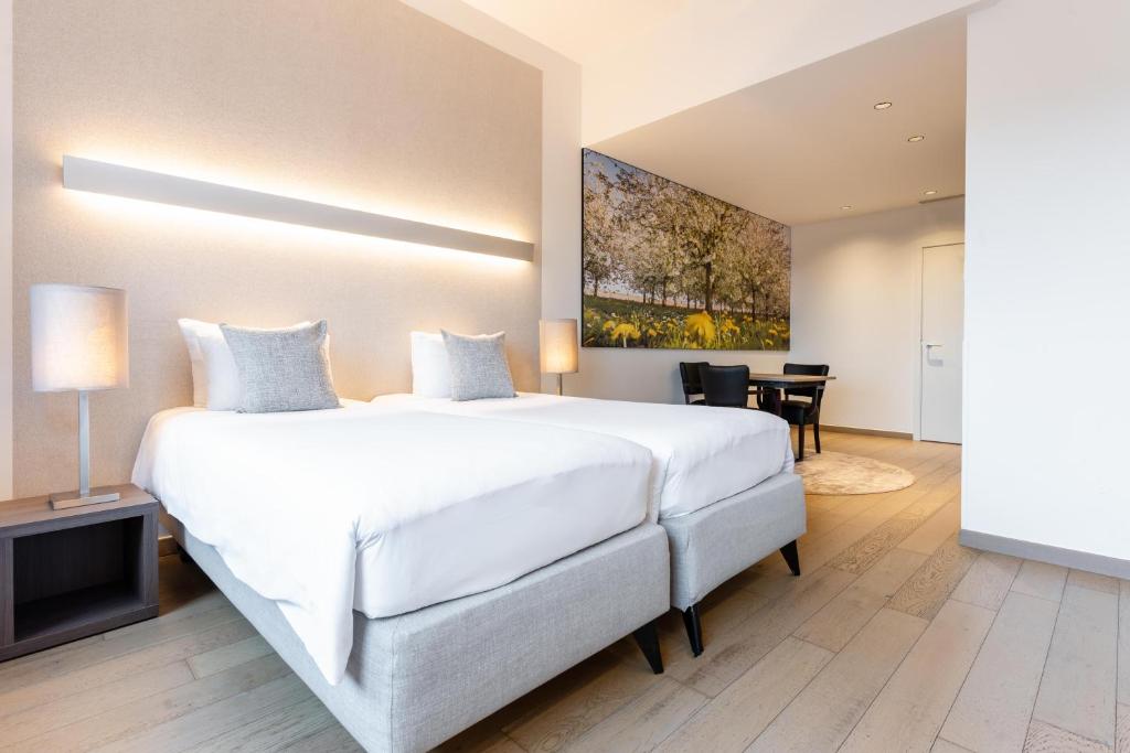 圣特雷登斯特岩酒店的卧室配有一张白色的大床和一张桌子