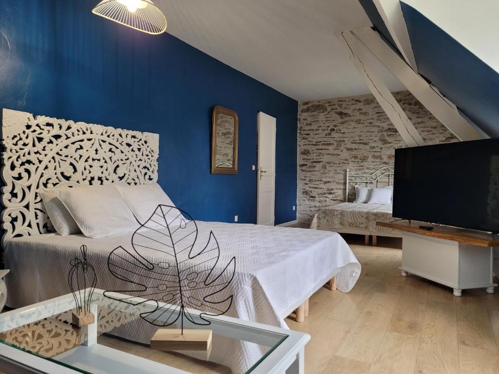 PréverangesDomaine des grands chênes的一间卧室设有一张床、一台电视和蓝色的墙壁
