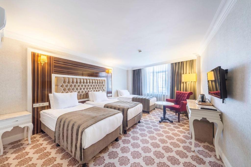 伊斯坦布尔Topkapi Old City Kensington Hotel ISTANBUL的酒店客房设有两张床和电视。