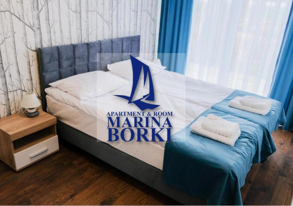 奥古斯图Apartamenty ZEFIR - MARINA BORKI的一间卧室,配有一张带码头标志的床