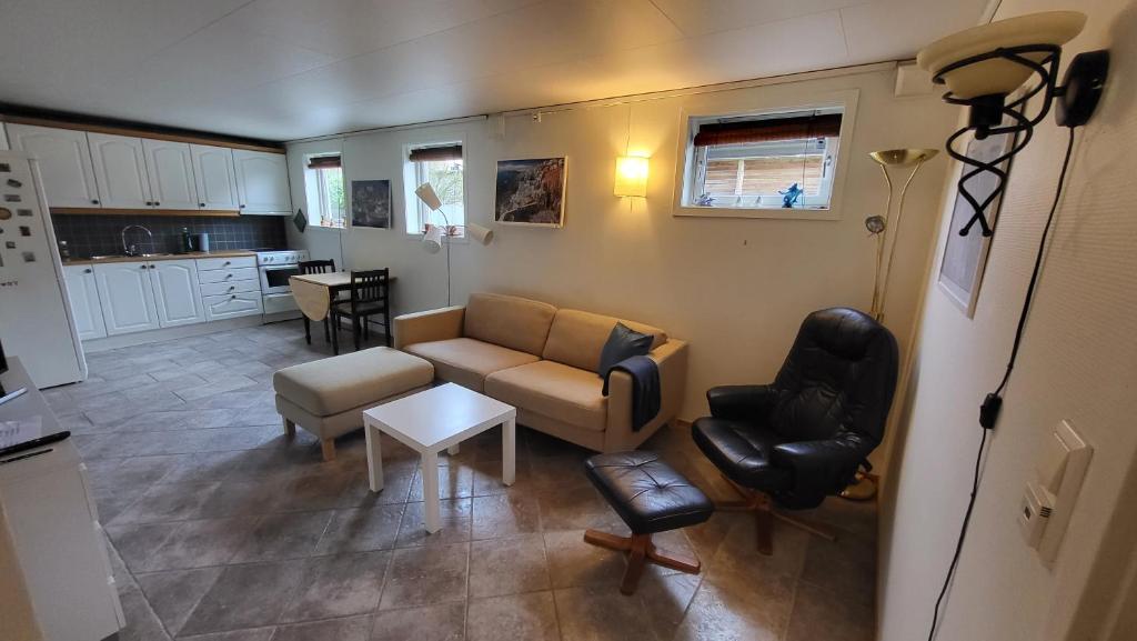 斯塔万格Flott leilighet i stille og rolig område, med gratis privat parkering!的客厅配有沙发、椅子和桌子