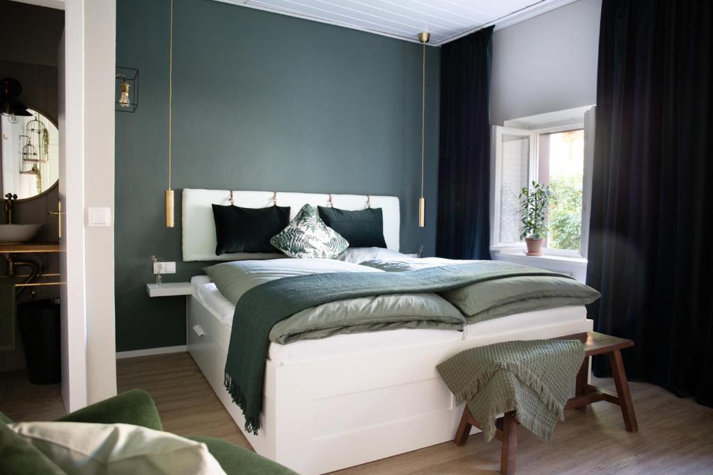 奥滕斯海姆Privatzimmer - Sieben an der Donau的一间卧室配有一张蓝色墙壁的床