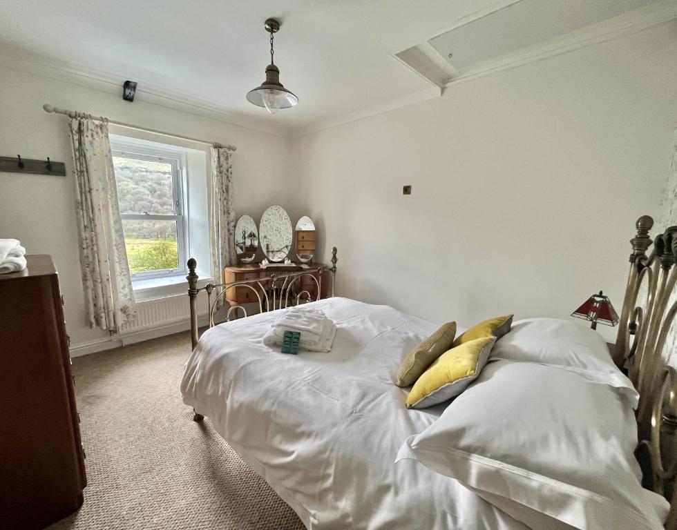特里迪格Attenborough Cottage - 2 Bedroom Cottage的一间卧室配有带白色床单和黄色枕头的床。