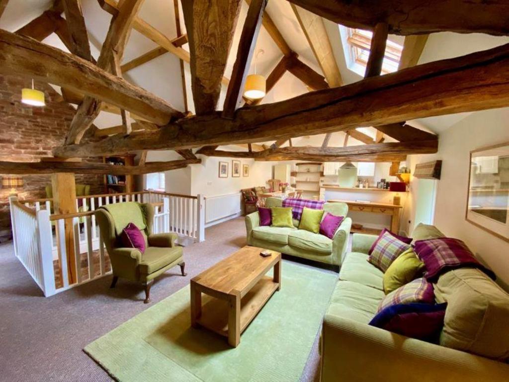 彭里斯Stunning barn minutes from the Lake District的客厅配有两张沙发和一张桌子