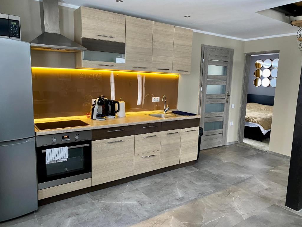 斯伽尔达PILADZI的厨房配有木制橱柜、水槽和床。