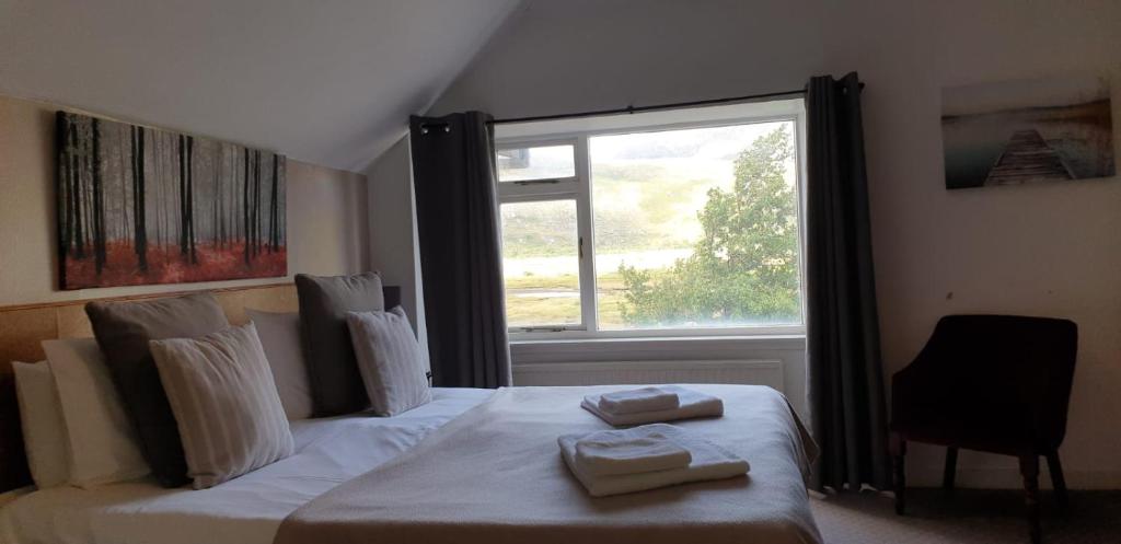 Dundonnell杜朵纳尔酒店的一间卧室配有一张床,上面有两条毛巾
