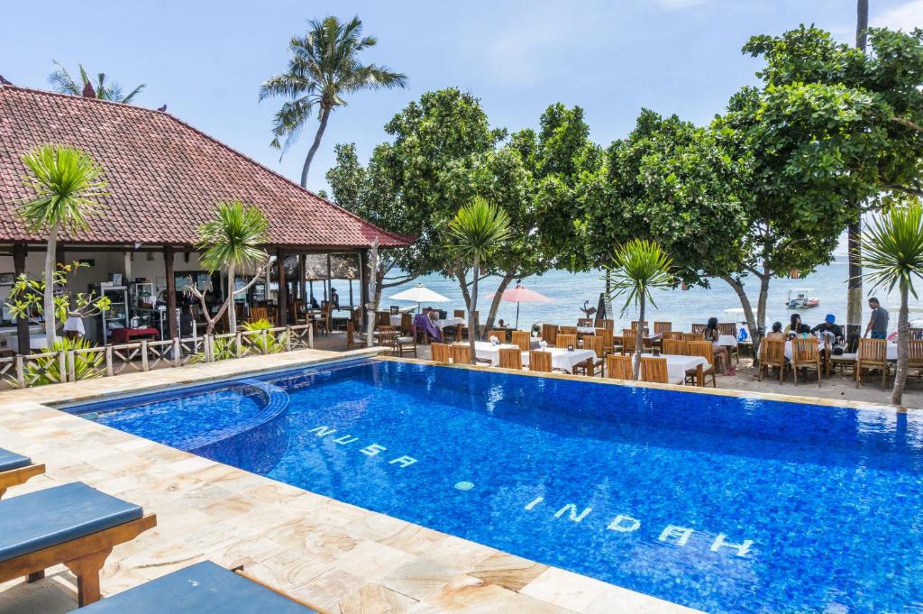 蓝梦岛努沙英达别墅酒店的一个带桌椅的度假村游泳池