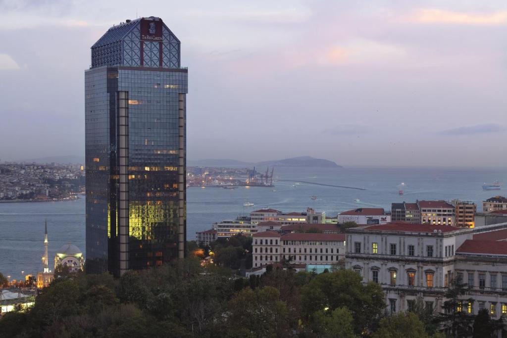 伊斯坦布尔伊斯坦布尔博斯普鲁斯海峡丽思卡尔顿酒店的一座高大的建筑,城市里灯火通明