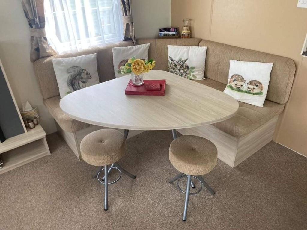 伯顿Borwick Lakes Haven的带沙发的客厅配有桌椅