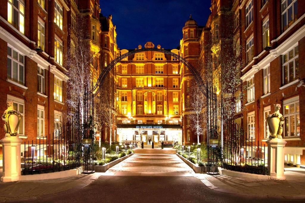 伦敦圣尔敏酒店 - 傲途格精选酒店的一座有拱门的建筑,在晚上
