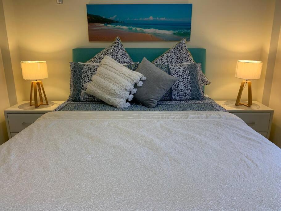 ParapBoutique Granny Flat的一间卧室配有一张带枕头的床和两盏灯。