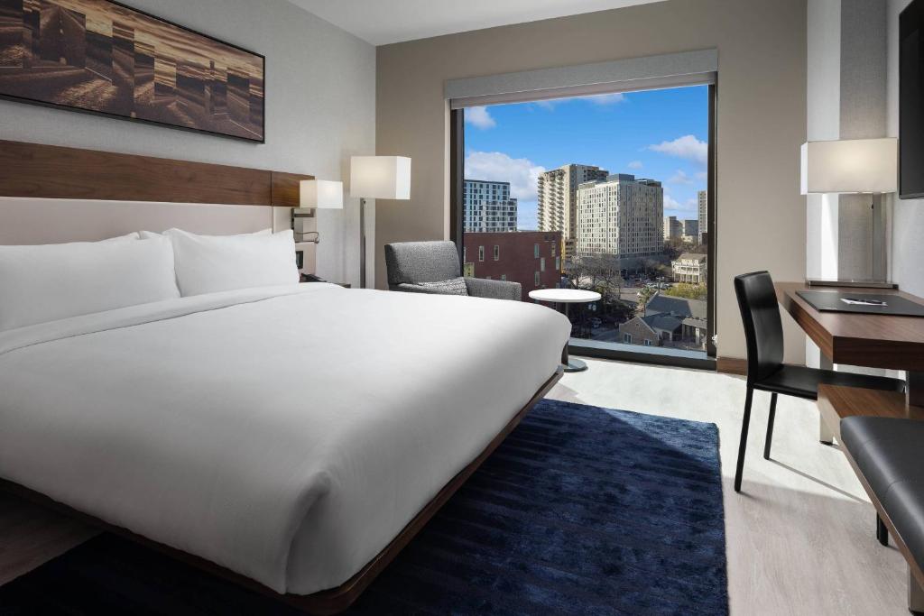 奥斯汀AC Hotel by Marriott Austin-University的卧室设有一张白色大床和大窗户