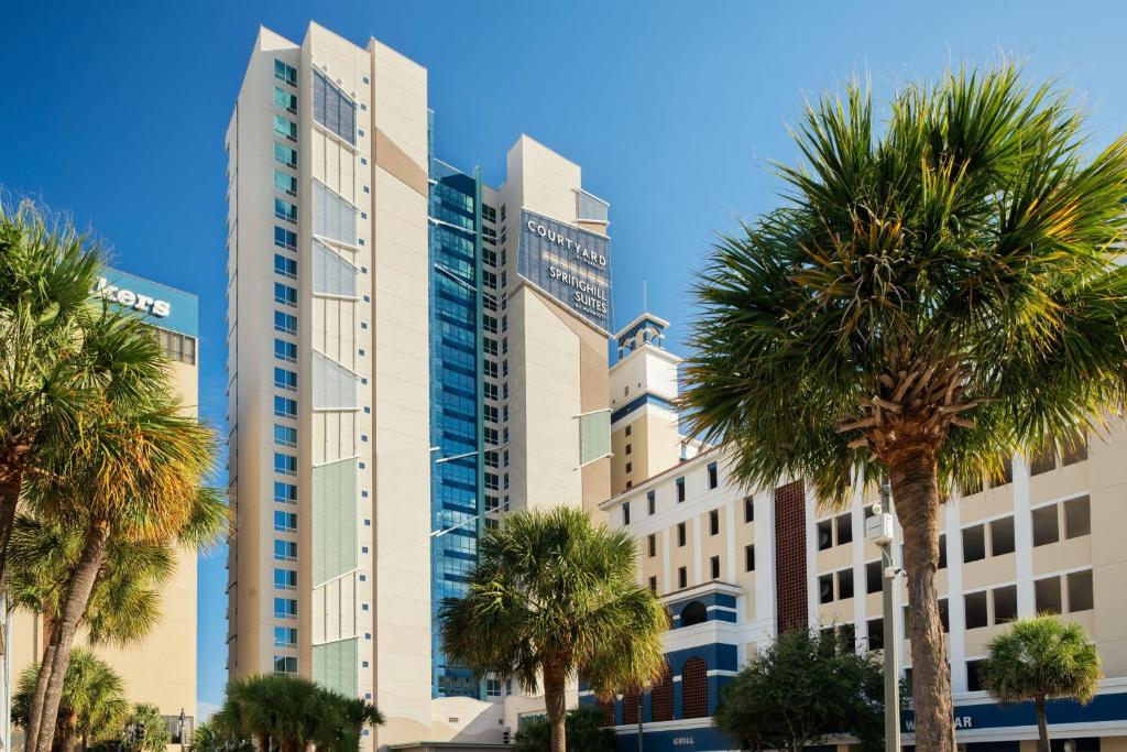 默特尔比奇Courtyard by Marriott Myrtle Beach Oceanfront的一座前面有棕榈树的高楼