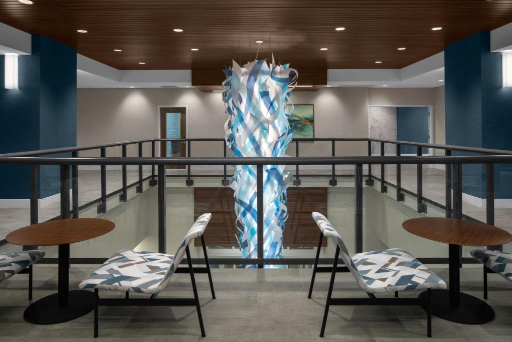 默特尔比奇Courtyard by Marriott Myrtle Beach Oceanfront的大堂设有椅子和大型雕塑