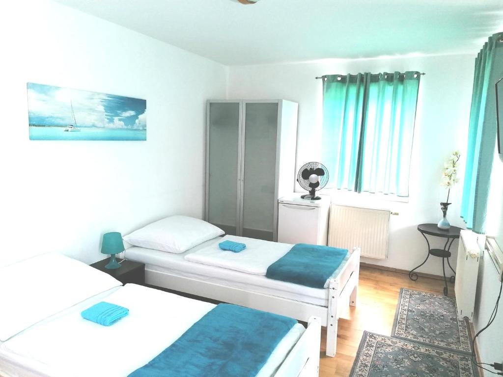 维也纳Favoriten-Rooms的小房间设有两张床和蓝色窗帘