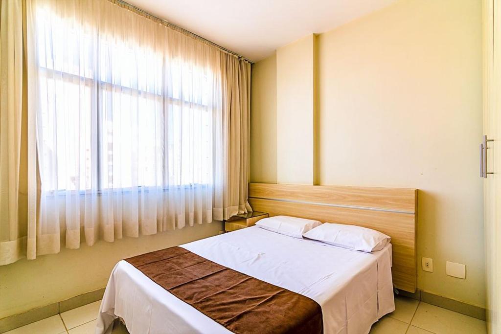 贝洛奥里藏特Villa Neves Residence的一间卧室设有一张床和一个大窗户