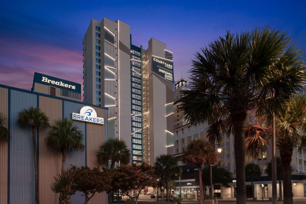 默特尔比奇SpringHill Suites by Marriott Myrtle Beach Oceanfront的一座前面有棕榈树的大楼