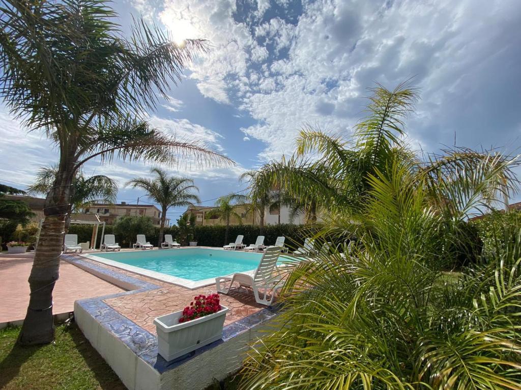 Ovile la MarinaVerter Home Resort的一个带椅子的游泳池,并种植了棕榈树