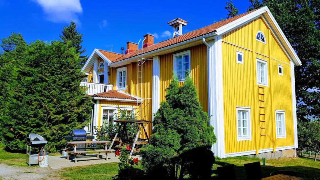 塞伊奈约基Siirilän tila的黄色和白色的房子,配有野餐桌