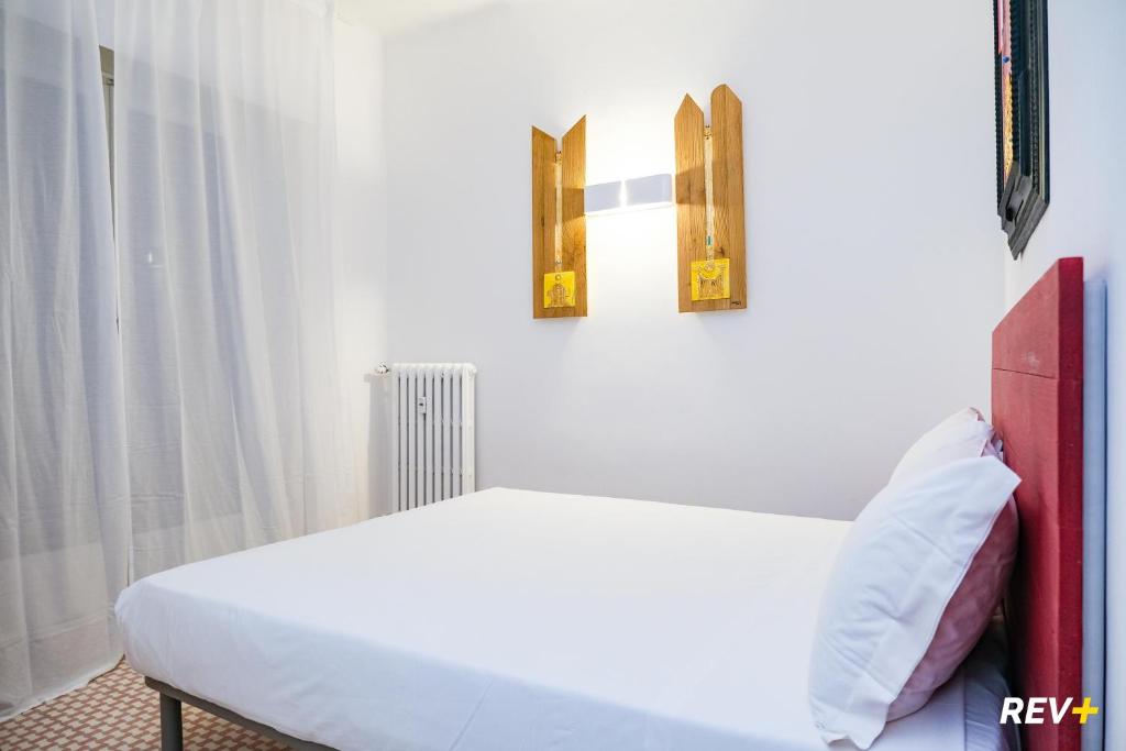 斯培西亚Lia Art Hotel的卧室配有一张白色床,墙上挂有两张照片