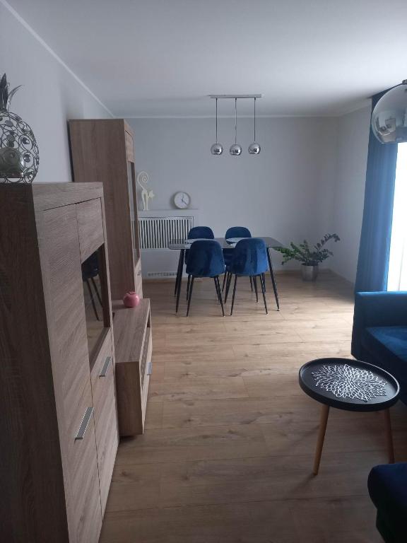 拉齐布日Apartament w centrum Raciborza的客厅配有桌子和蓝色椅子
