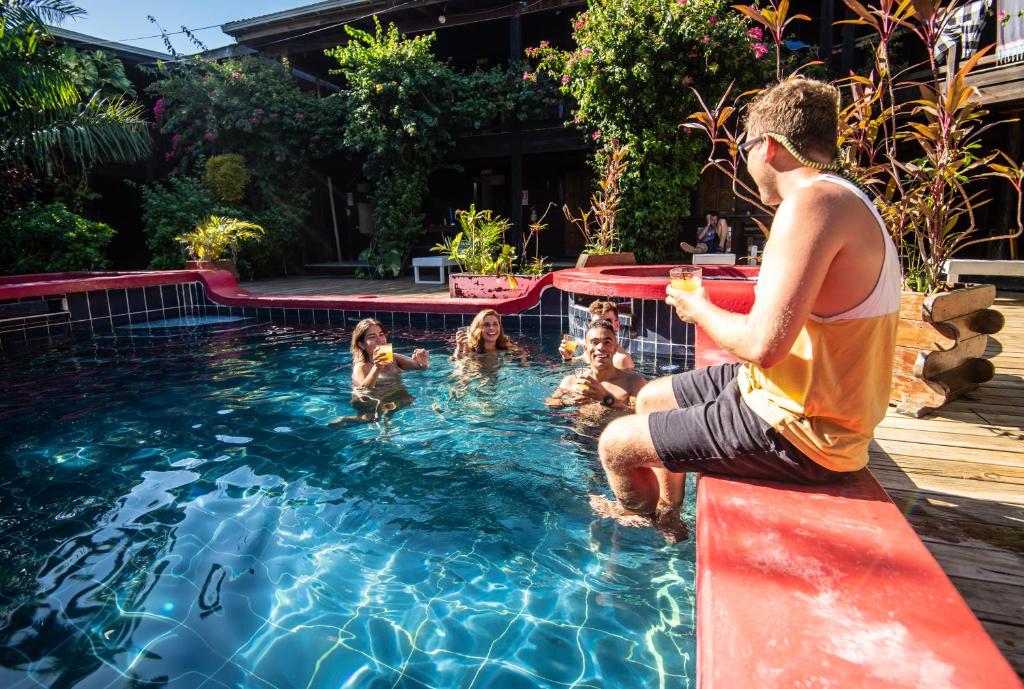 乌蒂拉Mango Inn Resort的坐在游泳池的树 ⁇ 里的人