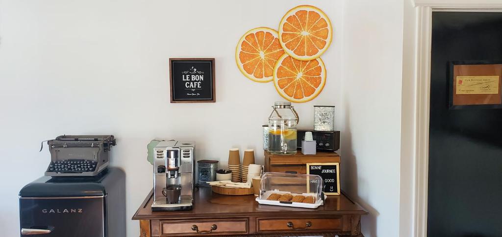 圣西蒙Motel Gentilhommière的厨房配有带咖啡壶的柜台,墙上挂有橙子