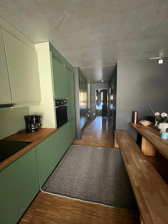 FavangFin leilighet ca 30 min med bil til Hunderfossen的铺有木地板的厨房配有绿色橱柜