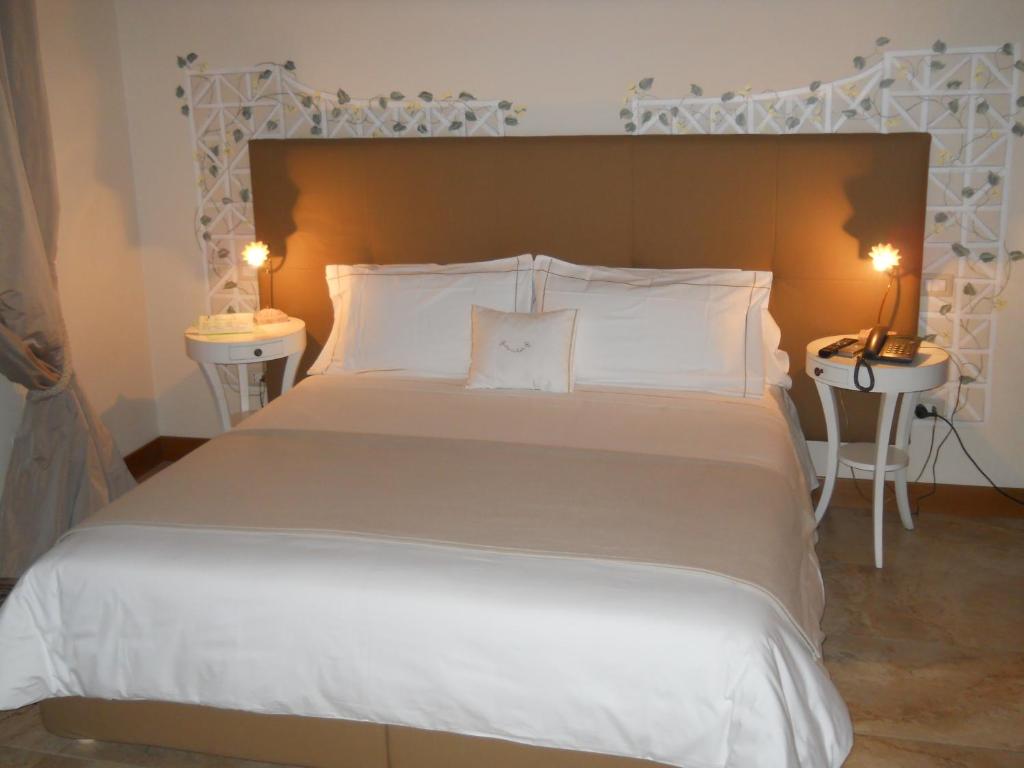 克罗托内美露住宿加早餐旅馆的一间卧室配有一张带两盏灯的大型白色床。
