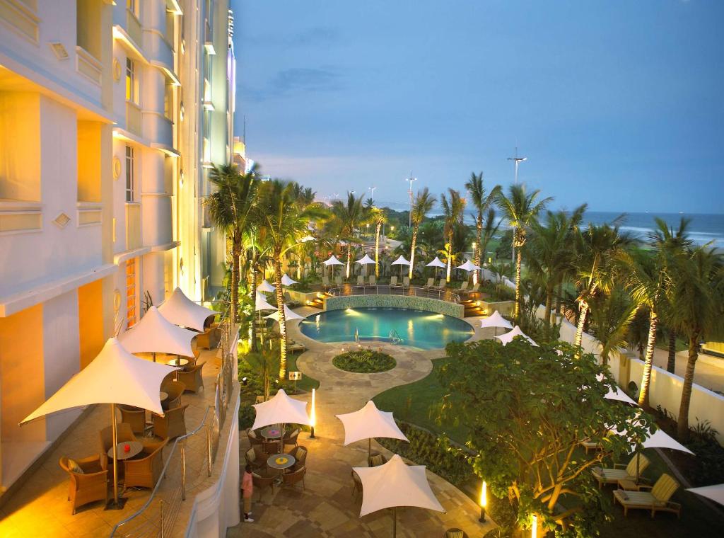 德班Suncoast Hotel & Towers的享有酒店阳台的景致,阳台配有游泳池和遮阳伞