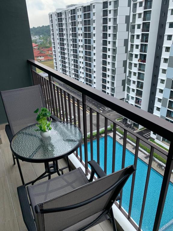 迪沙鲁Desaru Utama Apartment with Swimming Pool View, Karaoke, FREE WIFI, Netflix, near to Car Park的一个带桌椅的阳台