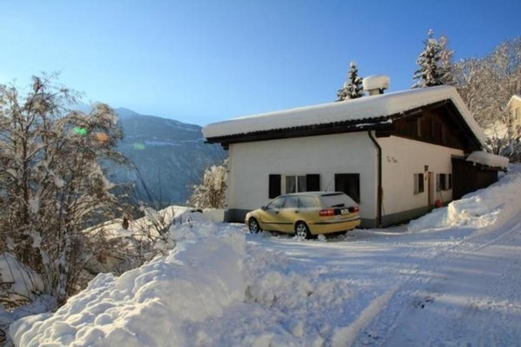 莱克斯Chalet Mon Refuge的停在雪覆盖的房子前面的汽车