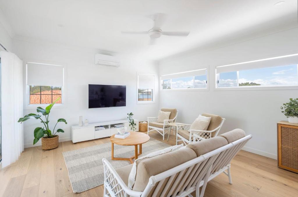 扬巴Biirinba Top Floor - oceanstays的客厅配有沙发、椅子和电视
