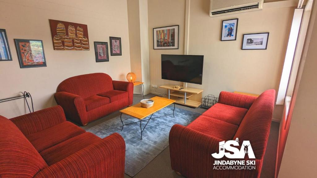 金德拜恩Razorback 2的客厅配有2把红色椅子和电视