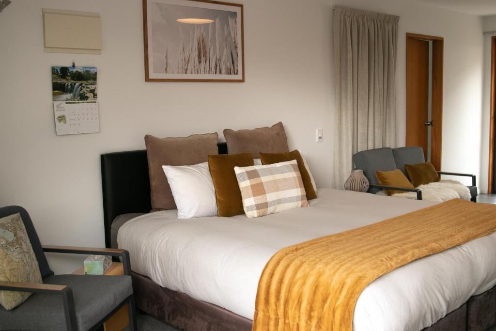 瓦纳卡Wanaka Lake Studio (New)的酒店客房带一张大床和一把椅子