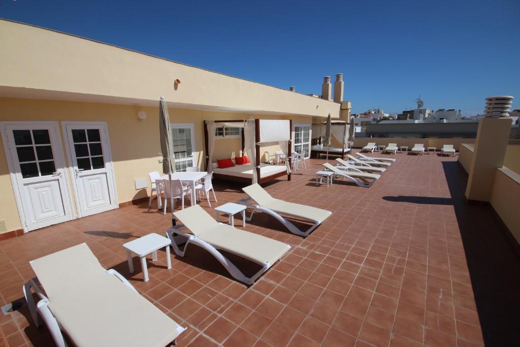 阿布里斯Apartamentos Isla Tenerife Sur的屋顶上一组躺椅和桌子