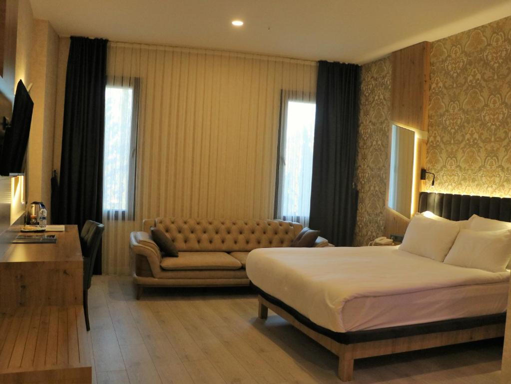 安塔利亚Isnova Hotel的酒店客房,配有床和沙发