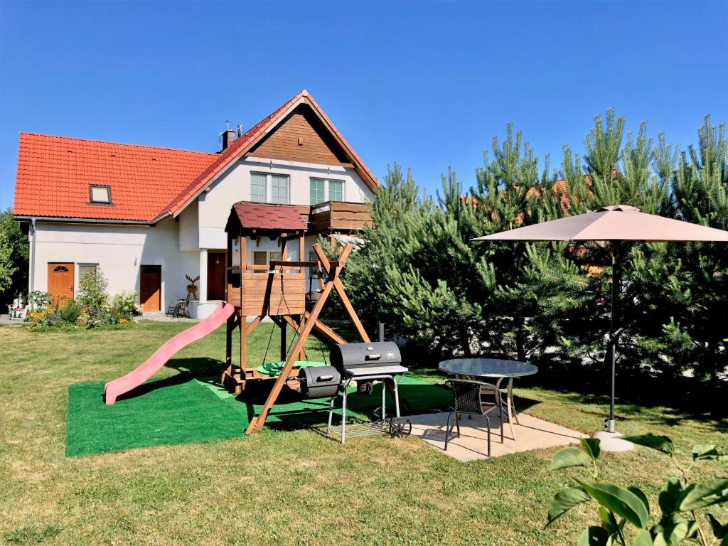梅斯瓦科维采Apartamenty Sun & Snow Villa Sportowa的一个带滑梯、桌子和遮阳伞的游乐场