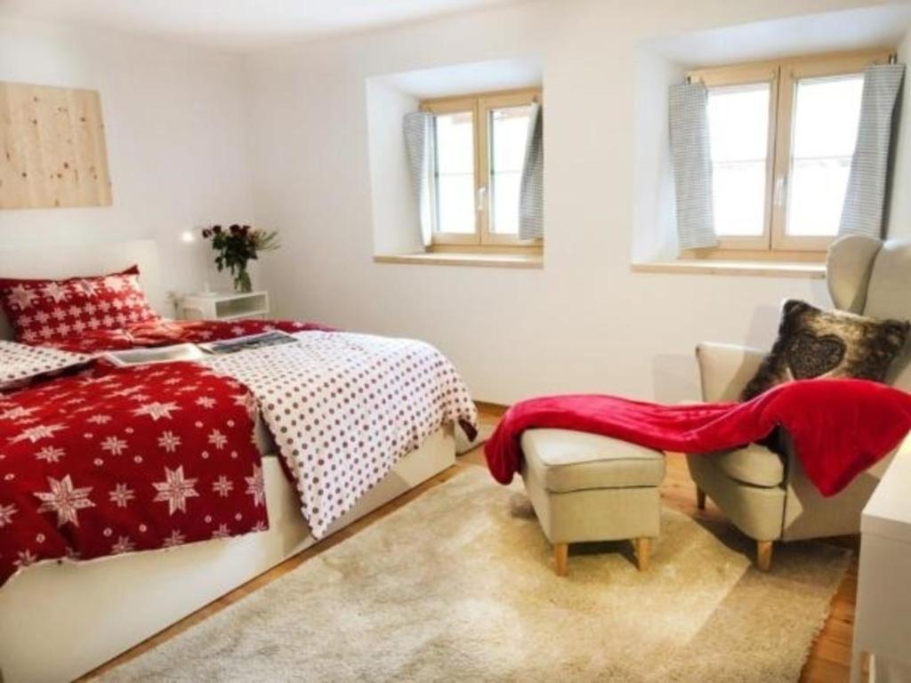 瓜尔达Grosszügige Komfort FEWO - ENGADIN HOLIDAYS的一间卧室配有一张床和一把椅子