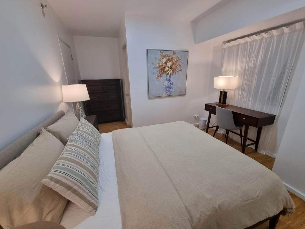 宿务Casa de Rosand的一间卧室配有一张床和一张书桌