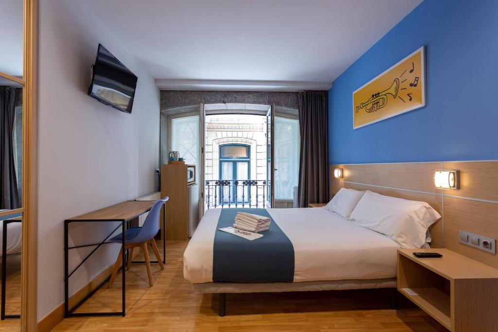 毕尔巴鄂Casual Arriaga的配有一张床和一张书桌的酒店客房