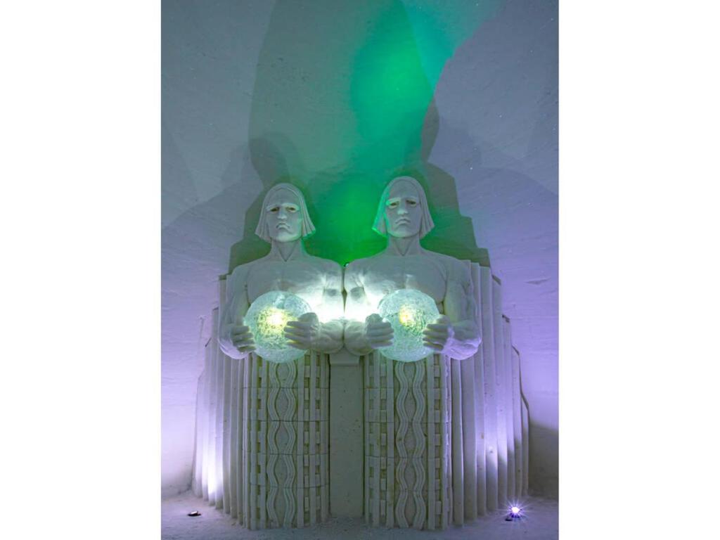 基蒂莱拉普兰雪村酒店 的两座两座手持灯的雕像