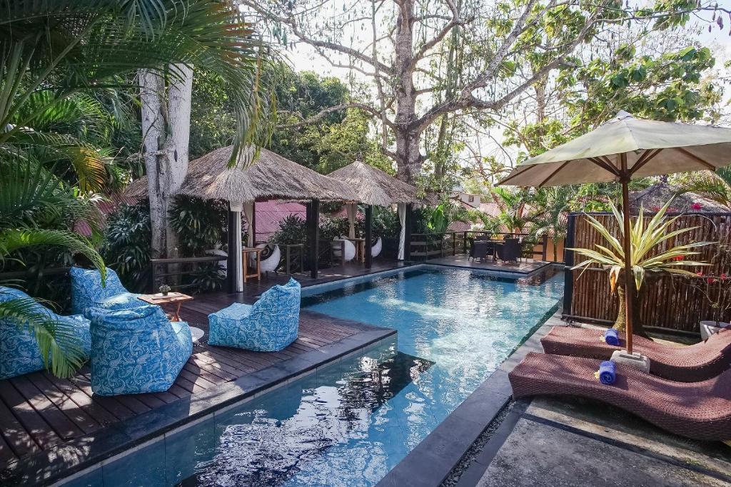 金巴兰Kampung 168的庭院内一个带椅子和遮阳伞的游泳池